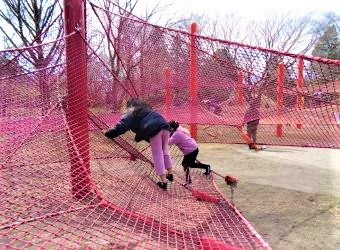 アスレチックで遊ぶ女児